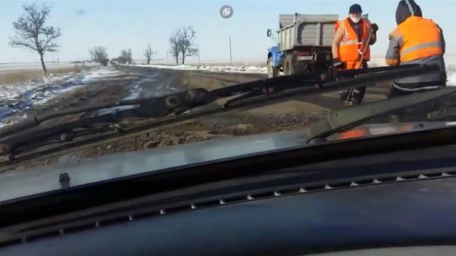 На участке трассы между Новотроицким и Геническом асфальт кладут прямо в мокрый снег