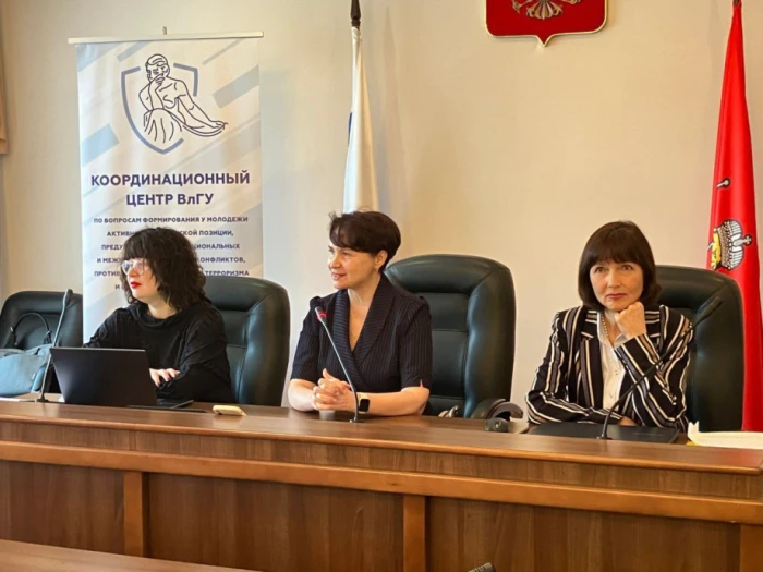 О. Блинова (сидить біля червоного прапора) на одній з наукових конференцій в рф. Фото окупаційного телеграм-каналу самопроголошеного херсонського вишу